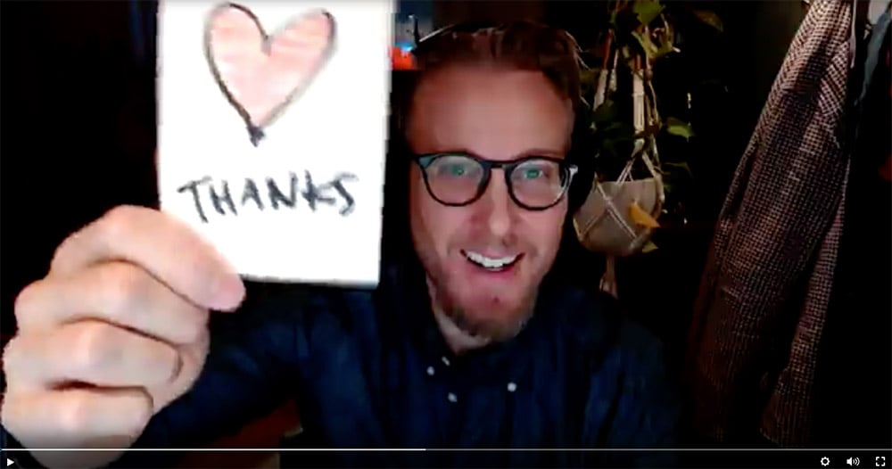 Mattias holding up a note saying thank you in video recording