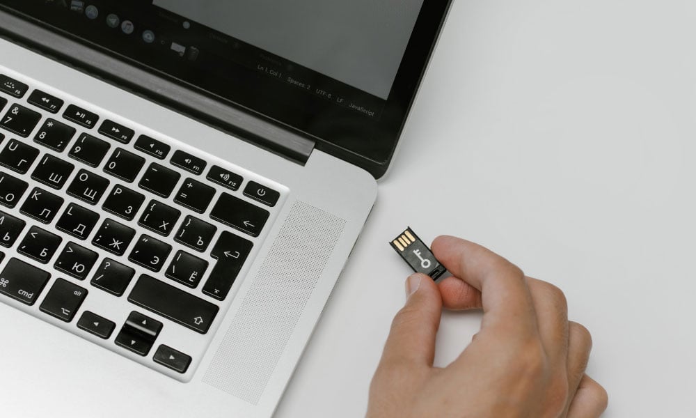 person inserting memory card into a laptop