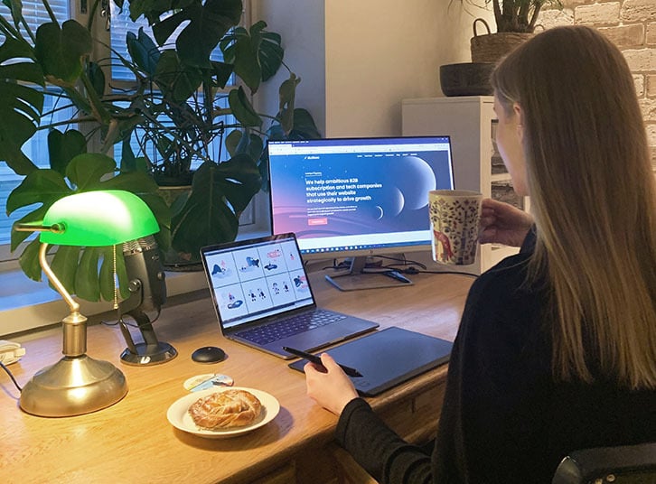 Designer sitting at desk working on two screens